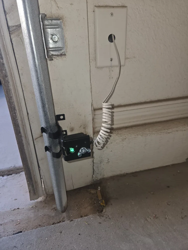 Properly aligned garage door safety sensor with green indicator light, installed by Copper State Garage Pros, San Tan Valley, AZ