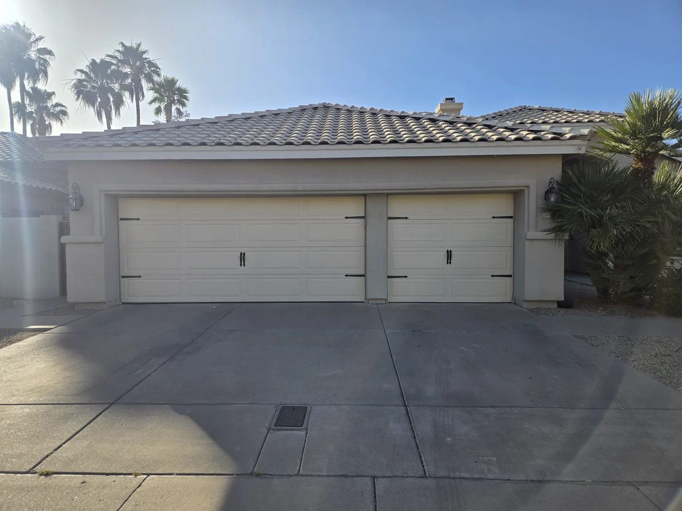 New flush-panel garage doors with black strap hardware installed by Copper State Garage Pros, East Valley, AZ